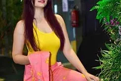 Shama sitting on floor in white skin-tight top and pink panty